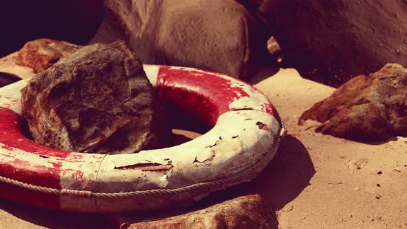 Old Life Buoy on Sand in Sunset alt