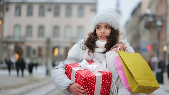 A Woman is Standing in the City Center During a Snowfall alt
