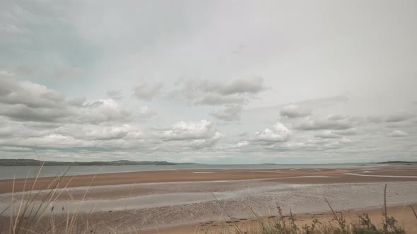 Time-lapse of fast moving clouds over the Firth or Forth Sea inlet near Edinburgh in Scotland. alt