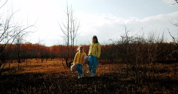 Kids Holding Fluffy Bears in Clothes in the Colors of the Ukrainian Flag alt