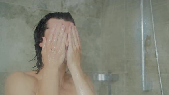 Handsome Young Long-haired Man Washing Face and Hair Taking Shower at Home alt