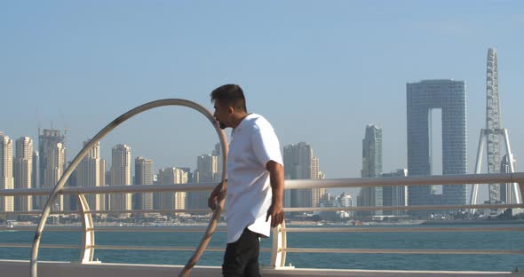 Wheel Gymnast is Leaning on the Railing Ain Dubai in the Background alt