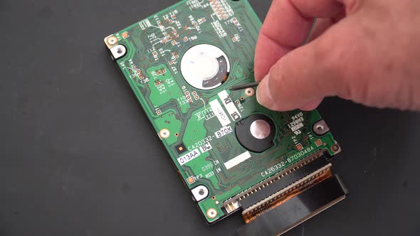 Computer hard drive being closely inspected by a technician . alt