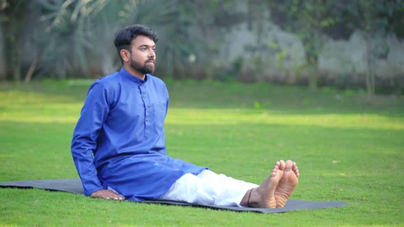 Indian man doing Dandasana or Staff Yoga Pose in an Indian traditional outfit Kurta Pajama alt