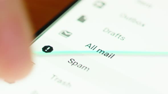 close up of hand browsing through mail folders a smartphone screen alt