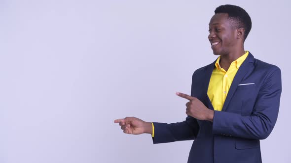 Young Happy African Businessman Pointing Finger and Showing Something alt