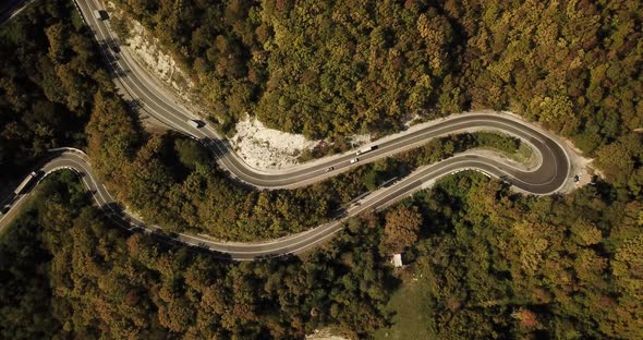 Aerial View of Car Driving Along The Winding Mountain Pass Road Through The Forest Trees. Autumn alt