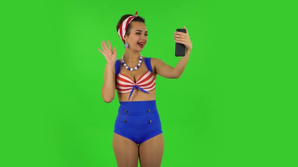 Beautiful Girl in a Swimsuit Is Talking for Video Chat Using Mobile Phone alt