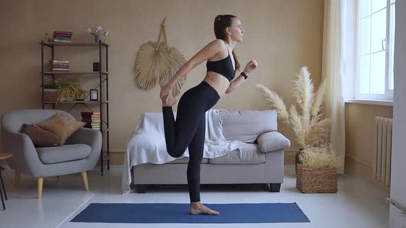 Young Yoga Woman Doing Dancers Pose Practicing Yoga at Home