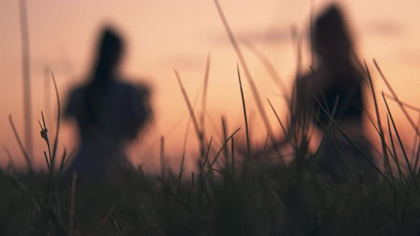 Girls Relaxing Sitting on Grass Talking on Summer Picnic