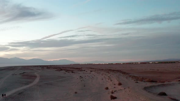 Freight train passing by near Salton Sea, Riverside. Aerial ascending shot alt