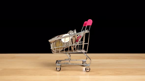 Stop motion animation Shopping cart with coins isolated on black background.