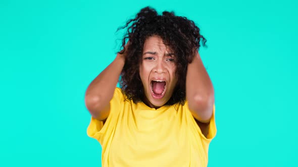 Portrait of Unpleasantly Surprised Shocked Mixed Race Girl on Teal Studio Background alt