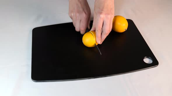 Woman cutting fresh lemons on the black board