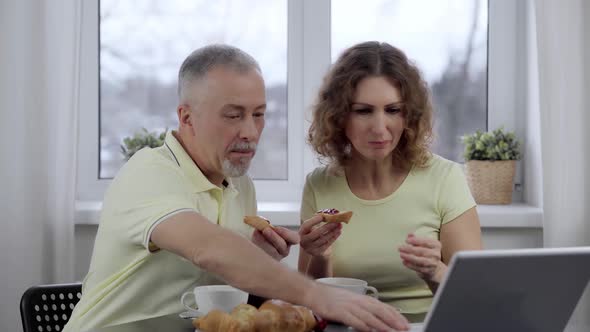 A Married Couple Has Breakfast Watches the News on Their Laptop and Has Fun