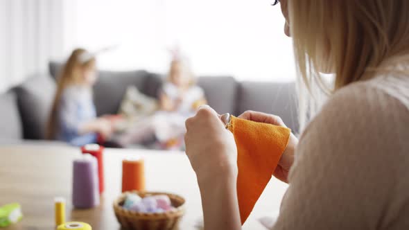 Video of mother sews and the children politely draw . Shot with RED helium camera in 8K alt
