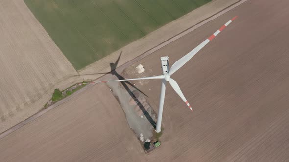 Aerial View Of Wind Turbine Generator At The Field On A Sunny Day. alt