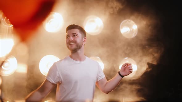 Professional bartender man juggling bottle on the smoke and light background alt