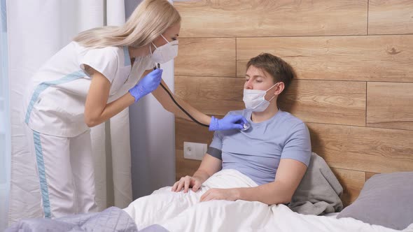Professional Female Doctor Is Listening To Breath of Male Patient