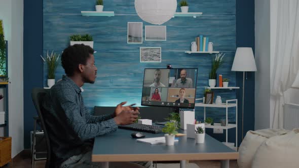 Man of African Ethnicity Using Online Conference Webcam Communication alt