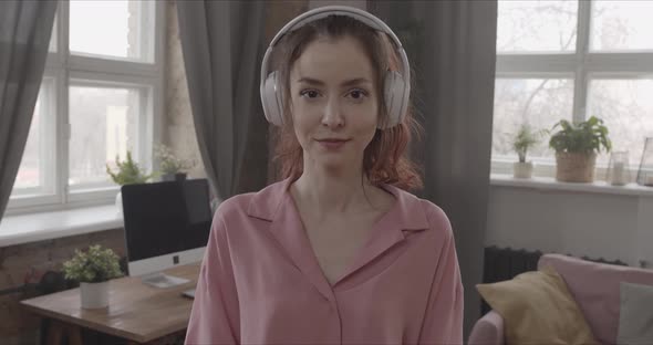 Girl Listening To Music With Headphones Looking Straight Into The Camera