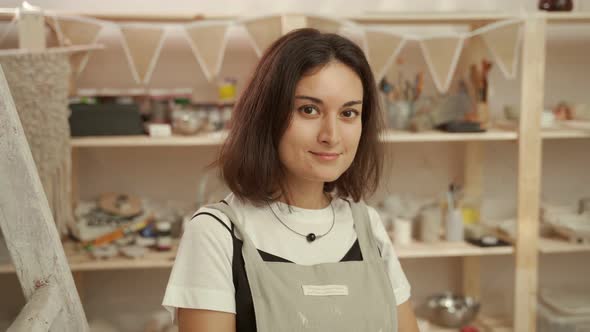 Smiling Craftswoman in Pottery Workshop