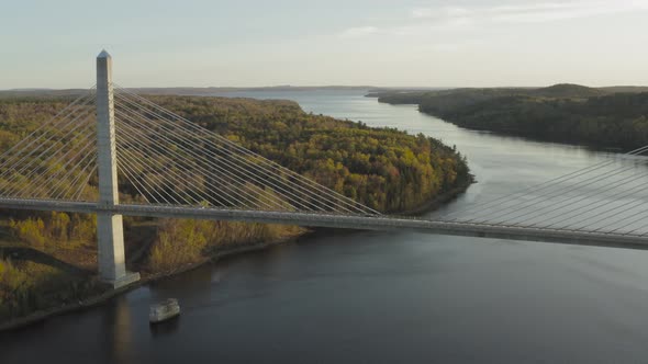 Cars driving across Penobscot Narrows Bridge autumn sunset AERIAL Pull back alt