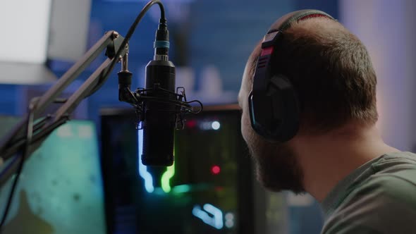 Pro Streamer Sitting on Gaming Chair Talking with Players Using Micorphone alt