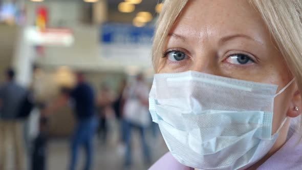 Woman Wearing Medical Protective Mask in Airport Terminal alt