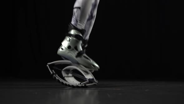 Close-up Motion of Trainer's Legs Performing in Kangoo Jumps Shoes. alt