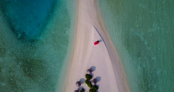 Luxury overhead island view of a white sand paradise beach and turquoise sea background in hi res 4K alt