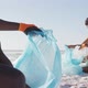 African american couple segregating waste with gloves on sunny beach - VideoHive Item for Sale