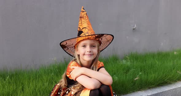 Cute Little Caucasian Girl with Blonde Hair Seven Years Old in Costume of Witch with Hat and Black