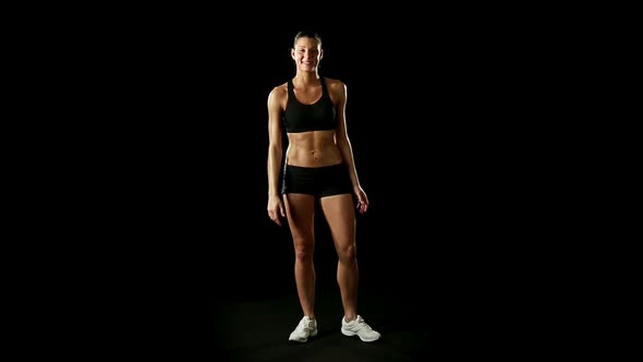 Young Athletic Woman Wearing Sporstwear is Relaxing Slow Motion Isolated on Black