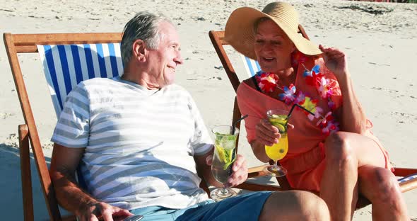 Senior couple taking selfie on mobile phone while having cocktail alt