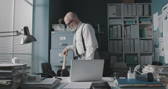 Angry businessman destroying his laptop