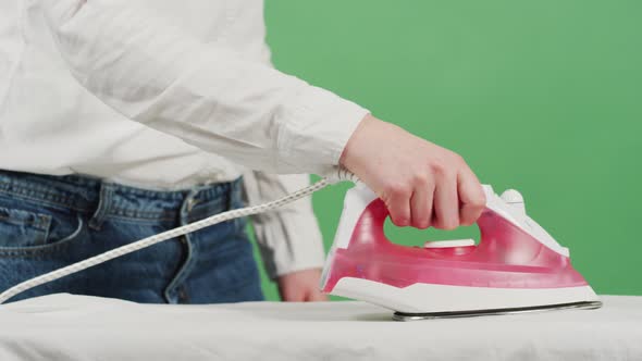 Woman ironing a white cloth alt