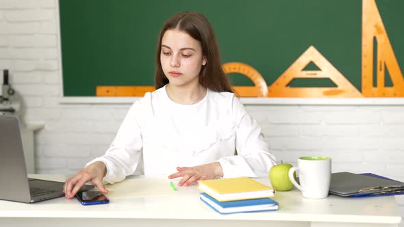 Serious Child Doing Classwork Using Smartphone in Classroom Mobile Education