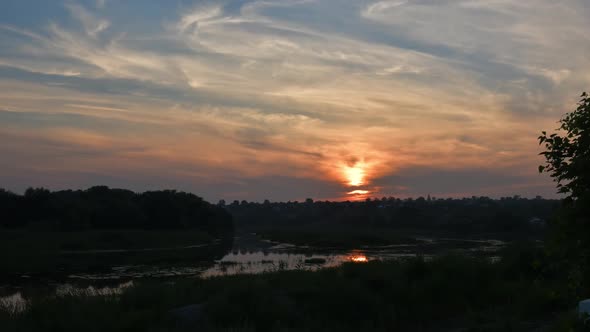 Time Lapse Sunset Landscape with Cirrus Clouds in Sky Over River Water