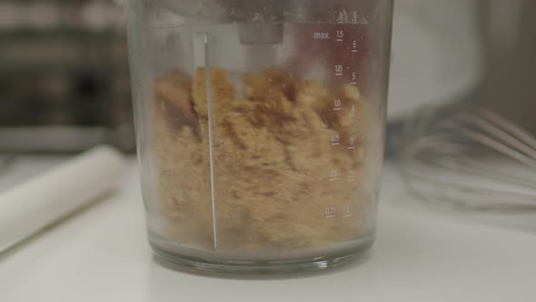 Grinding shortbread cookies in a blender for cheesecake base. Slow motion. alt