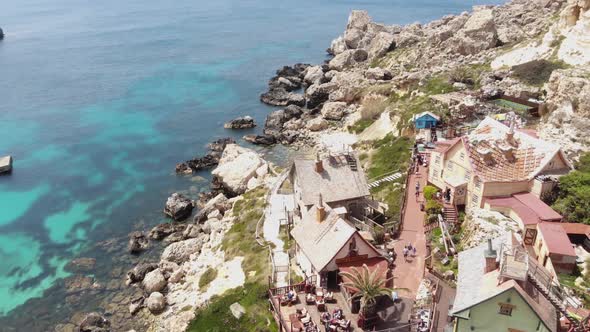 Popeye Village in Anchor Bay, also known as Sweethaven Village, Malta.  Aerial forward  alt