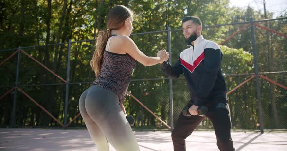 The Coach Trains a Beautiful Sportive Woman Sitting Outside on the Sports Field alt