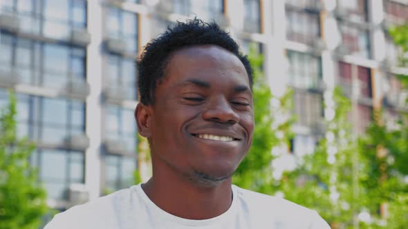 Close Up Smiling Afroamerican Man Drinks Coffee or Tea From White Paper Cup alt