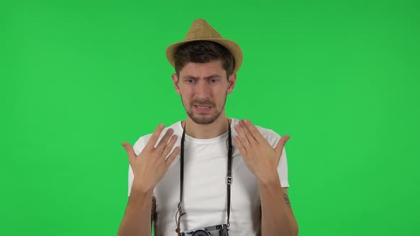 Portrait of Confident Guy Is Cooling Herself By His Hand, Suffering From High Temperature Weather alt