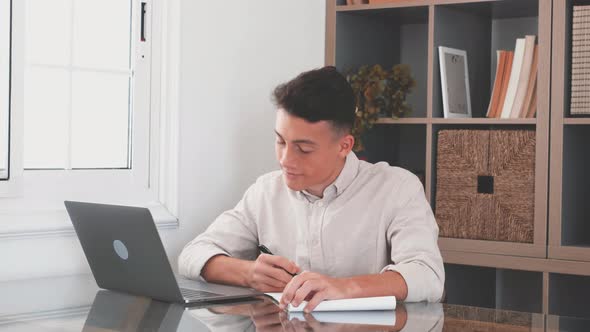 Happy young caucasian businessman smiling working online watching webinar podcast alt