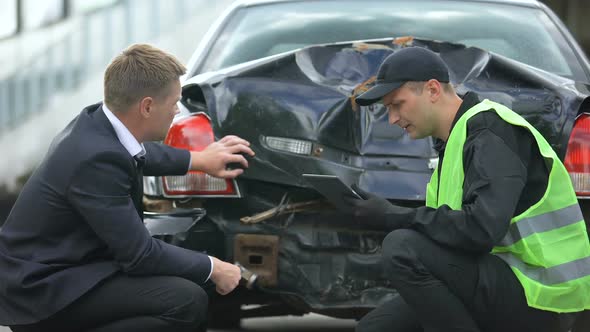 Insurance Company Worker Counting Compensation After Car Crash on Tablet PC alt