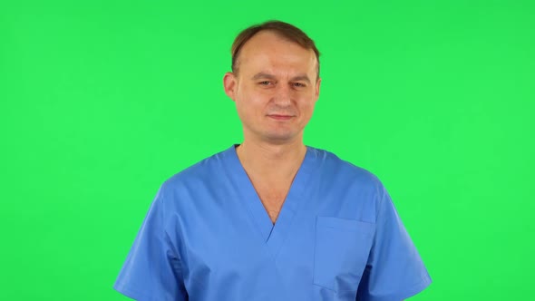 Medical Man Flirts and Winks While Looking at the Camera. Green Screen alt