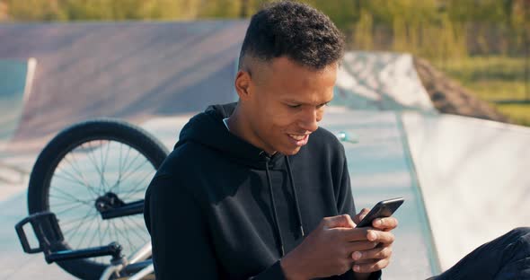 Darkskinned Handsome Talented Man Relaxes Afternoon on Ramps at Skatepark Rides Low Bmx Bike Holds alt