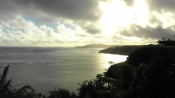 Island View Drone Fly Past Palm Trees Reveal Sunrise Over Kauai Hawaii North Coast Line alt