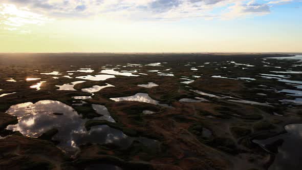 Lakes of calm water like mirrors reflecting a golden sunrise, Potholes, Washington alt
